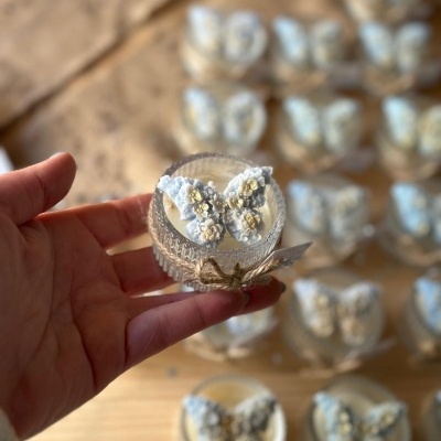 Pequeno frasco de vidro com tampa decorada com borboleta azul em relevo e laço de corda rústica