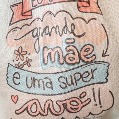 Tecido com ilustração e texto 'ÉS UMA grande mãe e uma super avó!!' decorado com flores e corações