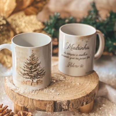 Duas canecas de Natal brancas em suporte de madeira com decoração de pinhas e neve artificial.