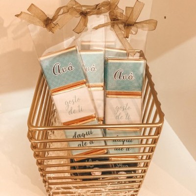 Três chocolates embalados com texto 'Avó' e 'gosto de ti' em cesto dourado
