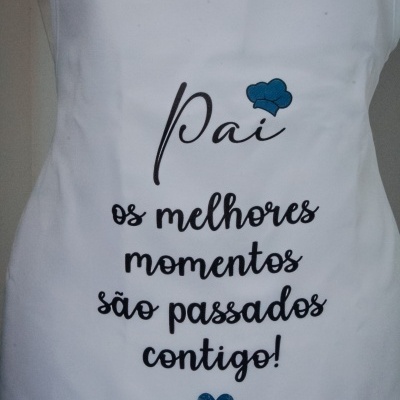 Avental branco com texto a preto e azul e desenho de chapéu de cozinheiro e coração azuis