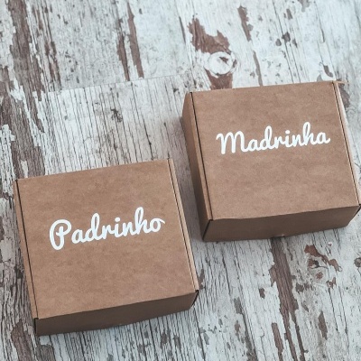 Duas caixas de cartão castanho claro com as palavras Padrinho e Madrinha em texto branco