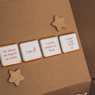 Bolachas quadradas e em forma de estrela decoradas dentro de caixa de cartão castanha