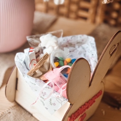 Cesta de madeira com papel estampado, doces e snacks em embalagem de tule