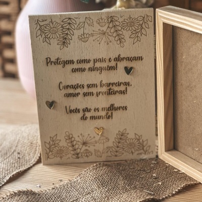 Caixa de madeira com mensagem gravada a laser e decoração floral, sobre tecido rústico e fundo com vaso e cesto