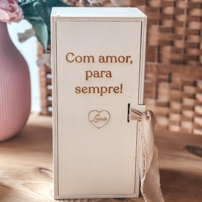 Caixa de madeira com texto gravado e fita bege pendurada