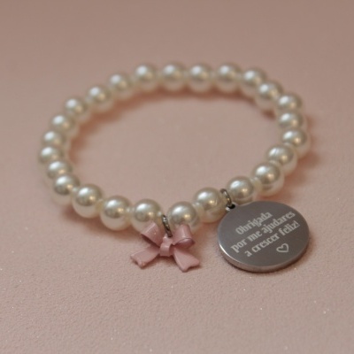 Pulseira de pérolas brancas com pendente metálico e laço rosa