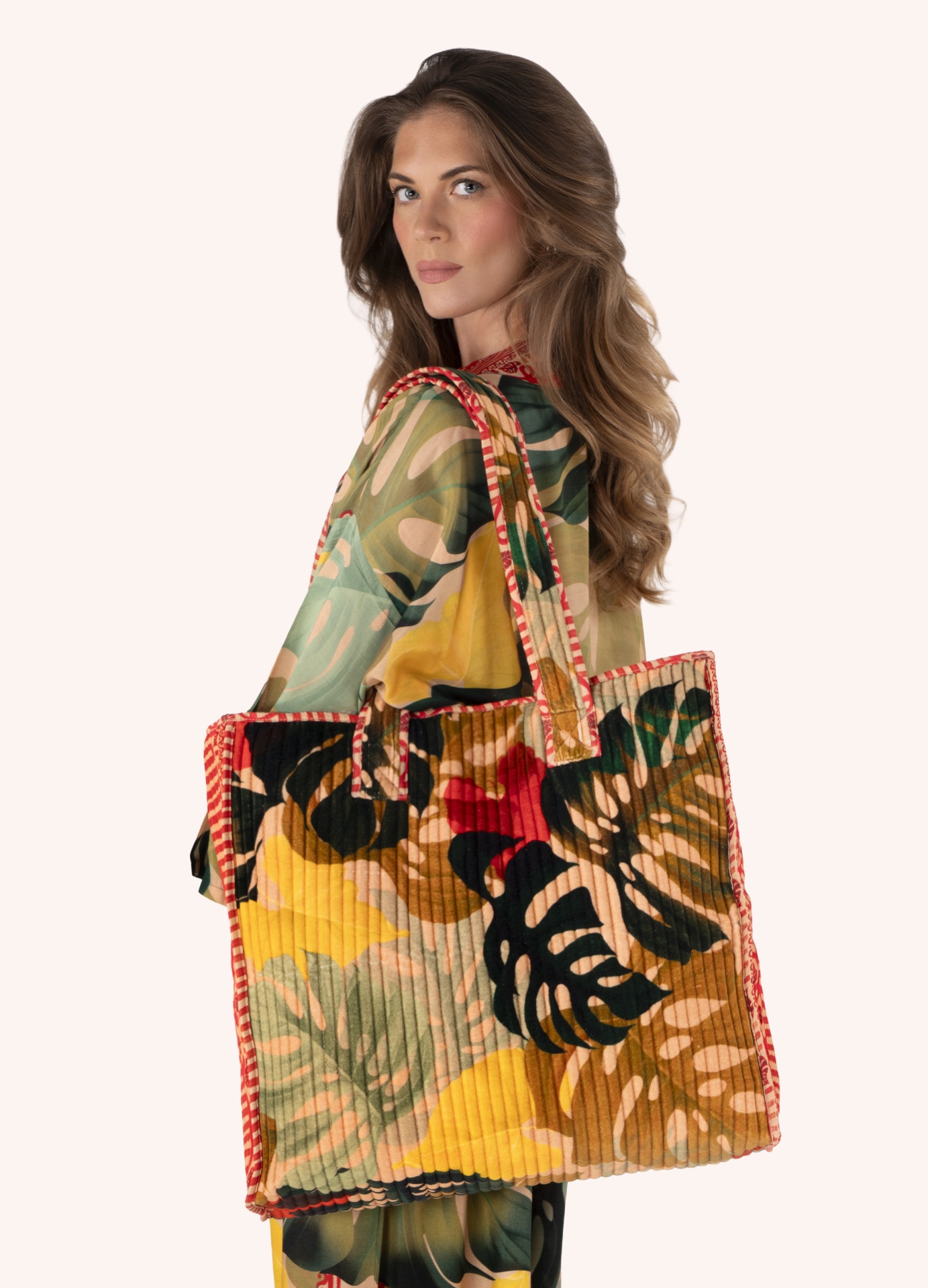 Tote de Veludo acolchoado Exotic Leaves - Powder Mala de tecido tropical colorida com alças e bordas vermelhas em modelo feminino