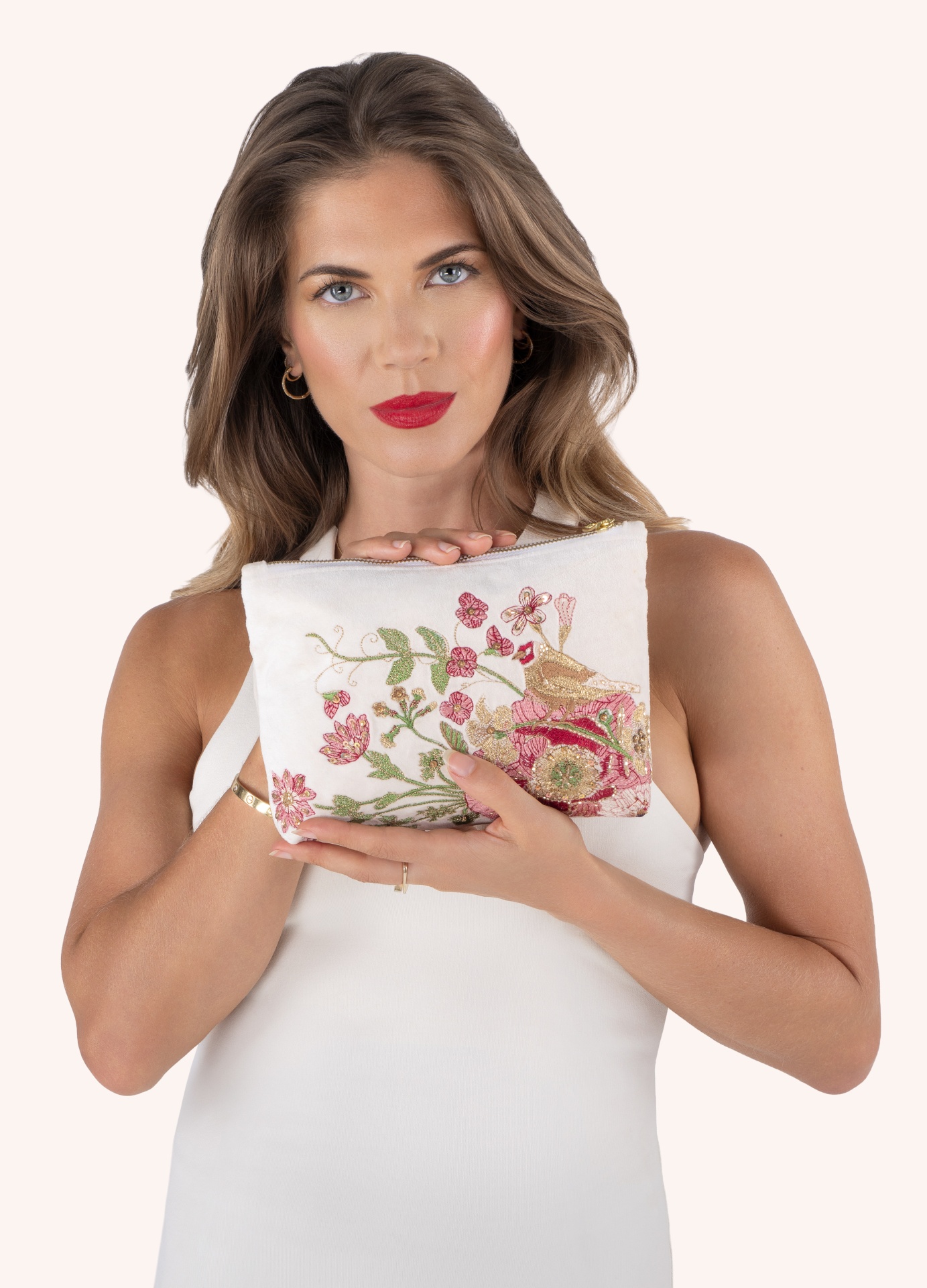 Bolsa Veludo Passarinho - Powder Mala de mão branca bordada com flores e pássaro, mulher a segurá-la com vestido branco.