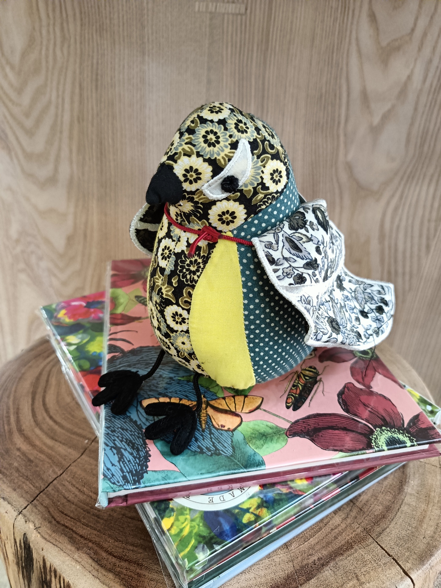 Pisa-Papéis Great Tit - Passarinho Boneco pássaro em tecido com padrões florais e bolinhas sobre livros com capas florais