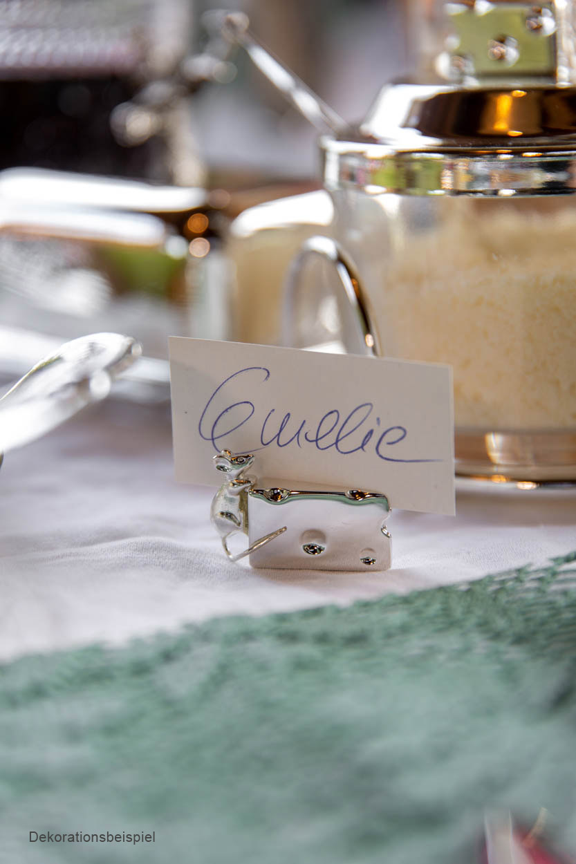 Marcadores de Mesa Ratinhos Hermann Bauer Suporte de cartão rena prateada com cartão escrito 'Cuillère' numa mesa com jarro metálico e açúcar ao fundo