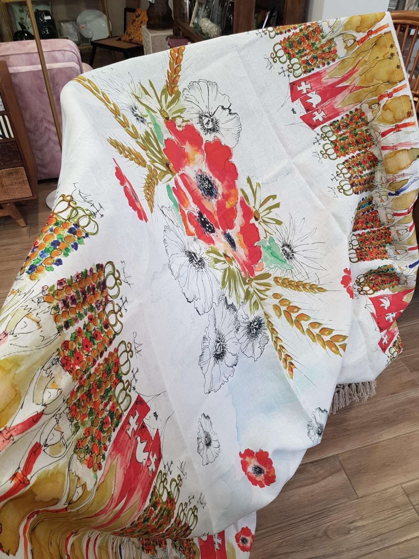 Toalha Linho - Festa dos Tabuleiros Tomar Manta decorativa branca com padrão floral colorido sobre móvel