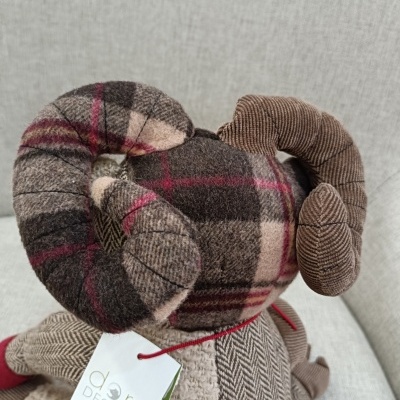 Boneco de carneiro de tecidos variados com etiqueta Dora Designs.