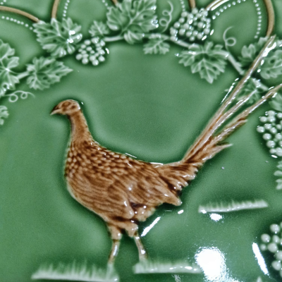 Prato decorativo de cerâmica verde com faisão e relevo