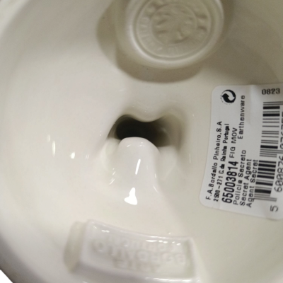 Interior de peça cerâmica branca com selo e etiqueta