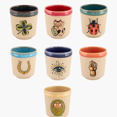 Sete copos de cerâmica pequenos com diferentes símbolos pintados