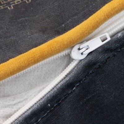 Fecho éclair branco numa capa de tecido amarelo e cinzento escuro com textura