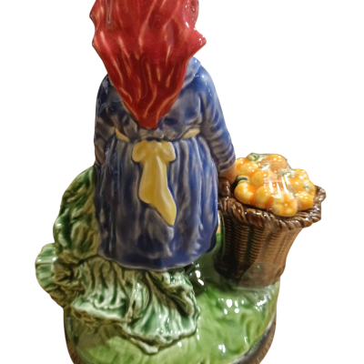 Estatueta cerâmica de mulher com avental azul e cesta de frutos