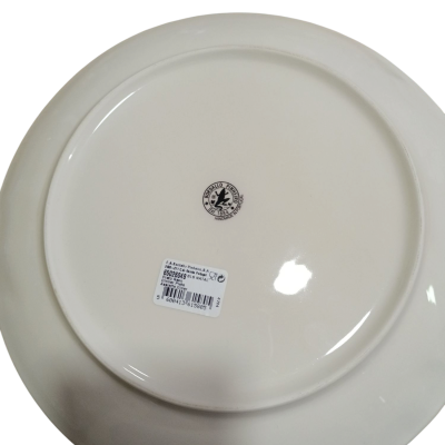 Prato branco de cerâmica visto por baixo com etiqueta e selo preto.