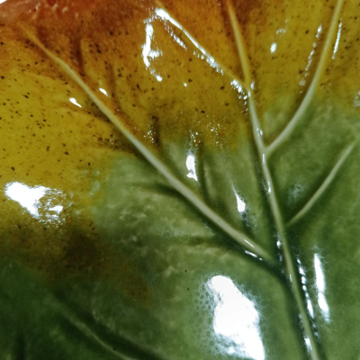 Prato cerâmico formato de folha verde e amarela com textura brilhante