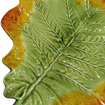 Prato cerâmico em forma de folha com cores verde, amarelo e laranja.