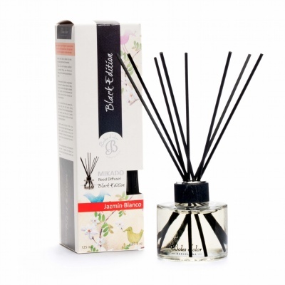 Difusor de aromas Mikado com varas pretas e embalagem branca com detalhes florais
