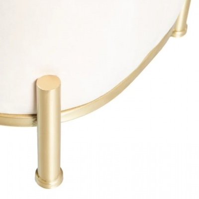 Base metálica dourada de móvel com estrutura branca arredondada e pés cilíndricos.