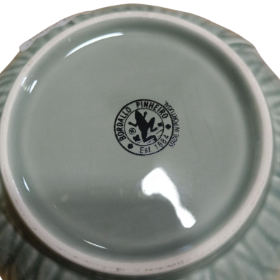 Parte inferior de prato de cerâmica verde com selo BORALTO PINHEIRO.