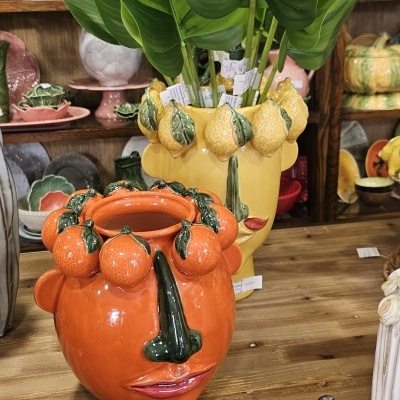 Vasos cerâmicos em forma de rosto com frutas decorativas em loja