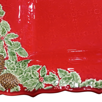 Prato cerâmico vermelho com decoração de azevinho, bagas e pinhas