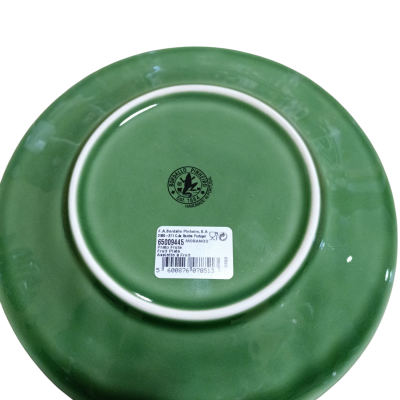 Base de prato verde em cerâmica com etiqueta e logotipo da fábrica.