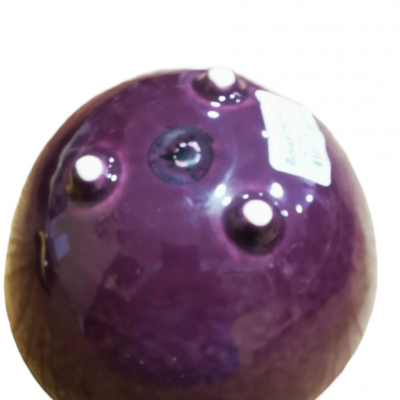 Peça de cerâmica roxa com quatro pés brancos na base