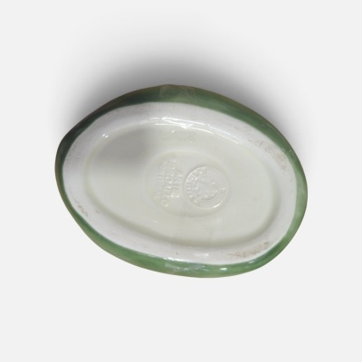 Base oval de cerâmica branca com borda verde e inscrições em relevo no fundo
