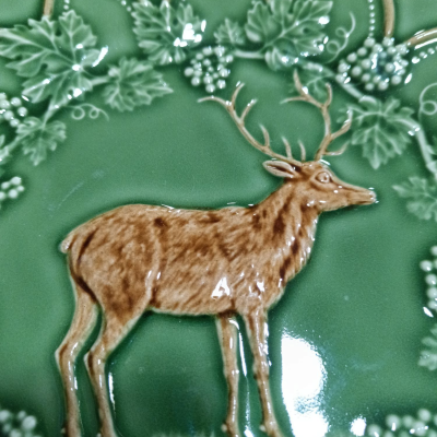 Prato decorativo verde com relevo de veado castanho e folhas