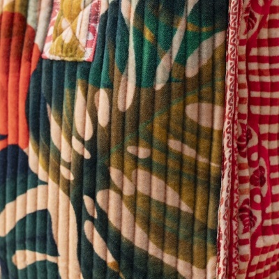 Tecido acolchoado com padrão de folhas e bordas vermelhas com padrões brancos