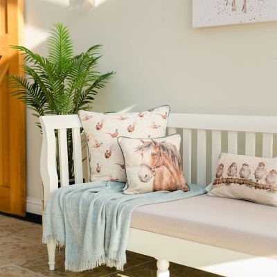 Sofá branco com almofadas decorativas e manta azul clara