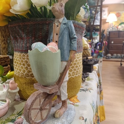 Estátua decorativa de coelho empurrando carrinho com ovos coloridos feita em madeira ou resina