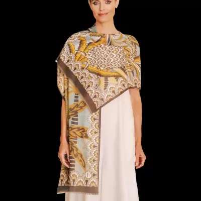 Mulher com vestido branco e xale estampado tons castanhos e amarelos