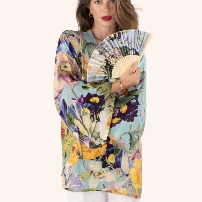 Mulher de camisa floral colorida e leque com padrão semelhante