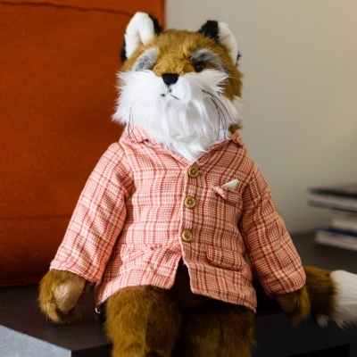 Boneco de raposa de pelúcia com casaco xadrez rosa sentado