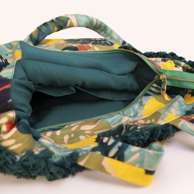 Mala estampada floral com interior verde e fecho dourado aberto