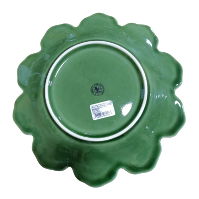 Prato verde de porcelana em forma de flor visto pelo fundo com etiqueta e selo