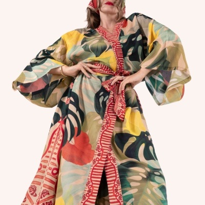 Robe colorido com padrão de folhas e detalhes vermelhos, usado com lenço de cabeça combinando