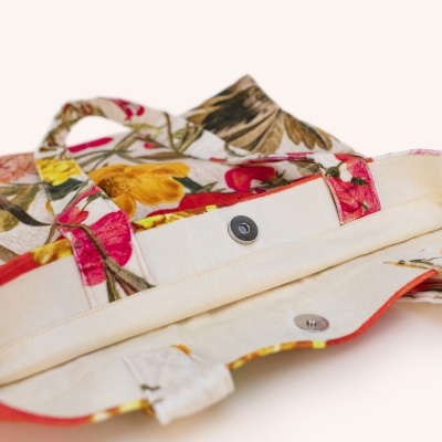 Mala de tecido com padrão floral e fecho magnético aberto