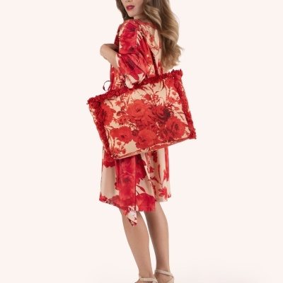 Mulher a usar vestido e bolsa com padrão floral vermelho