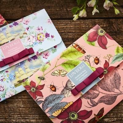 Carteiras florais coloridas de tecido em fundo de madeira rústica