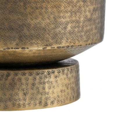 Objeto decorativo metálico dourado envelhecido com textura pontilhada.