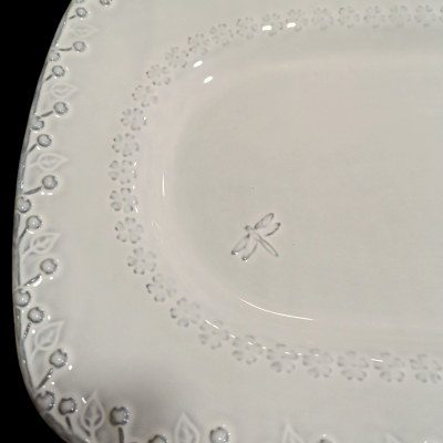 Prato oval branco com textura floral e desenho de libélula em relevo