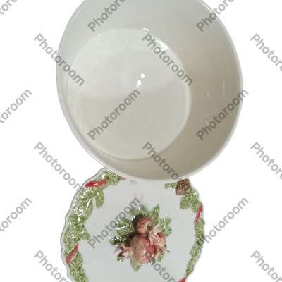 Taça de cerâmica branca sobre prato decorativo com folhas verdes e frutos vermelhos.