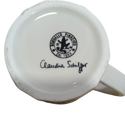 Base de caneca branca com selo BORRALLO PINHEIRO e assinatura Claudia Schiffer